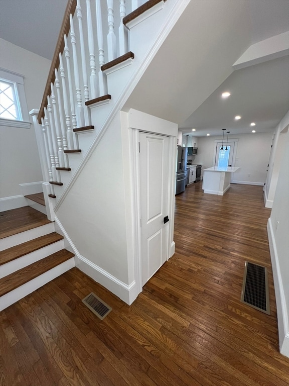 stairway with dark hardwood / wood-style floors