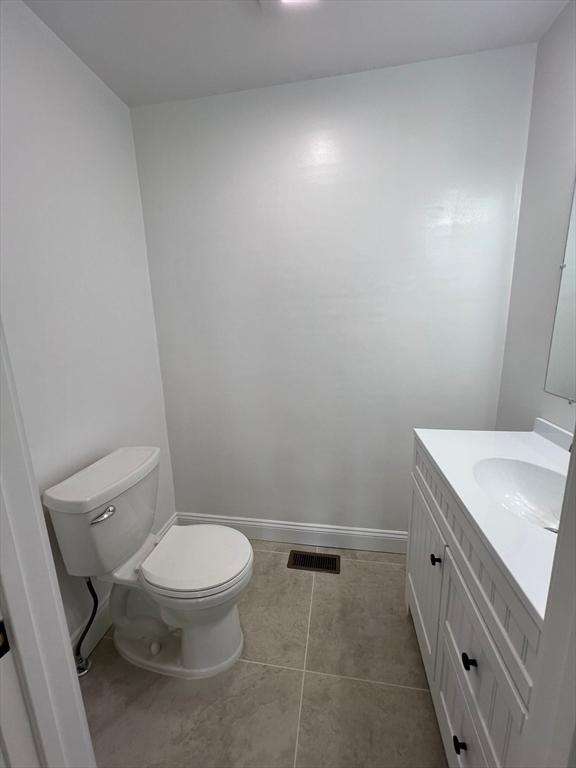 bathroom with vanity, tile patterned flooring, and toilet