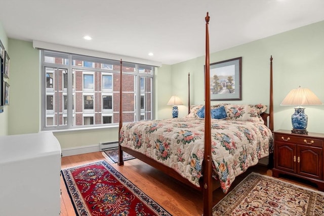 bedroom featuring light wood-type flooring and baseboard heating