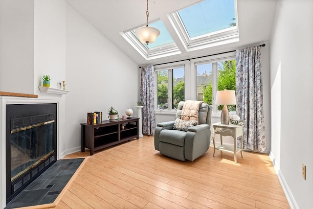 42 Brickett Hill Cir Unit 114, Haverhill, MA 01830 - sitting room with a skylight, a fireplace with flush hearth, light wood finished floors, and vaulted ceiling