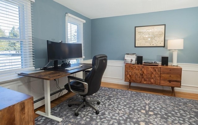 office featuring a wainscoted wall, baseboard heating, and wood finished floors