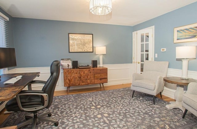 office area with a chandelier, a wainscoted wall, and wood finished floors