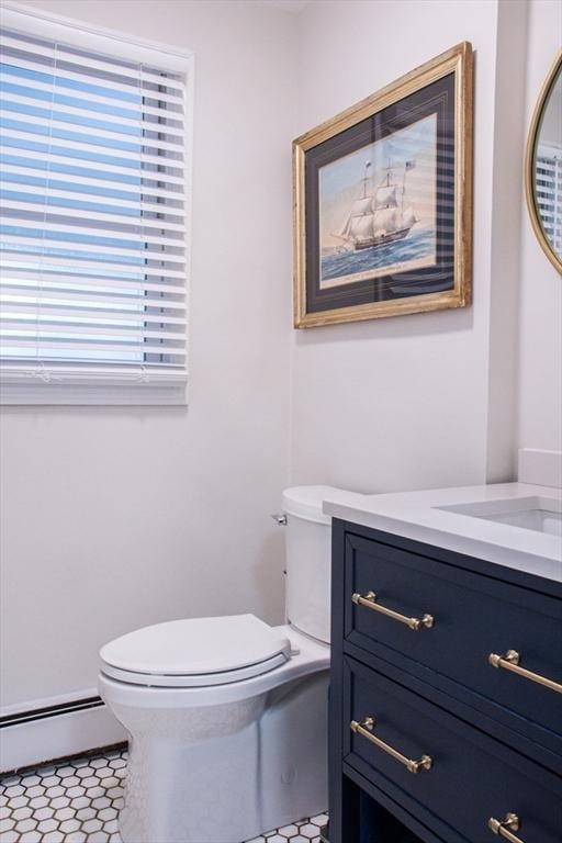 bathroom featuring vanity, toilet, and baseboard heating