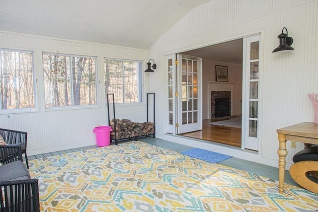 sunroom featuring a fireplace and vaulted ceiling