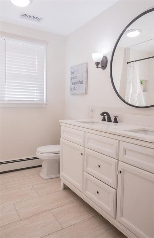 full bath with vanity, toilet, visible vents, and baseboard heating