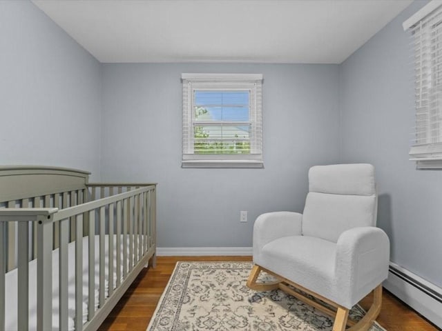 189 Brigham Hill Rd, Grafton, MA 01536 - bedroom featuring a baseboard heating unit, wood finished floors, baseboards, and a nursery area