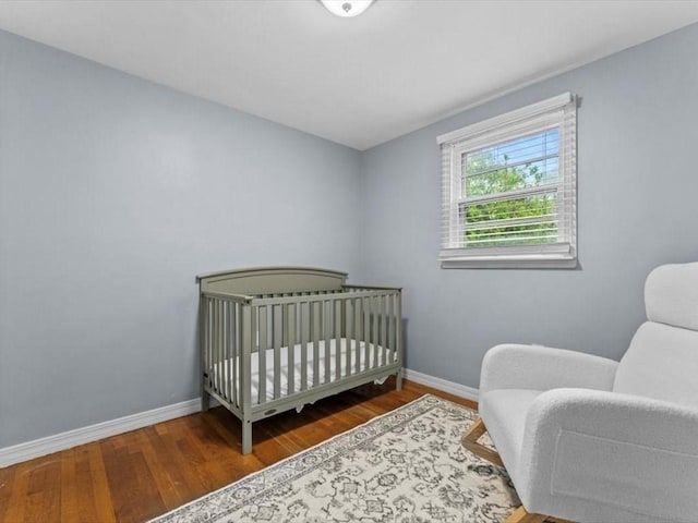 189 Brigham Hill Rd, Grafton, MA 01536 - bedroom featuring baseboards, wood finished floors, and a crib