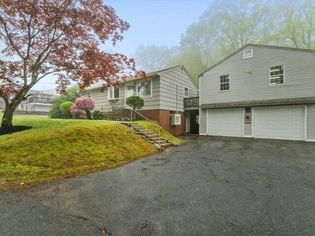 189 Brigham Hill Rd, Grafton, MA 01536 - view of front facade with an attached garage, asphalt driveway, and a front lawn
