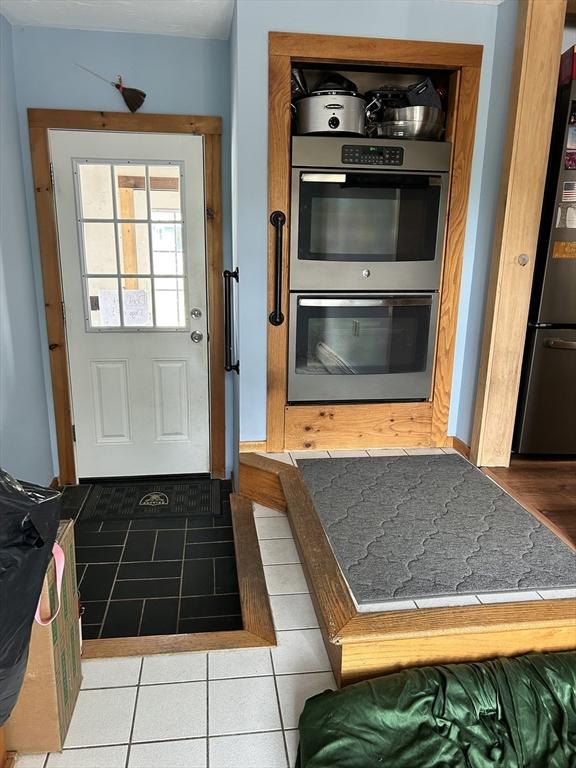554 Main St, Becket, MA 01223 - kitchen featuring stainless steel double oven, freestanding refrigerator, and tile patterned flooring