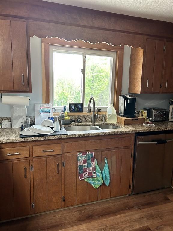554 Main St, Becket, MA 01223 - kitchen with stainless steel dishwasher, a sink, dark wood-type flooring, light stone counters, and brown cabinets