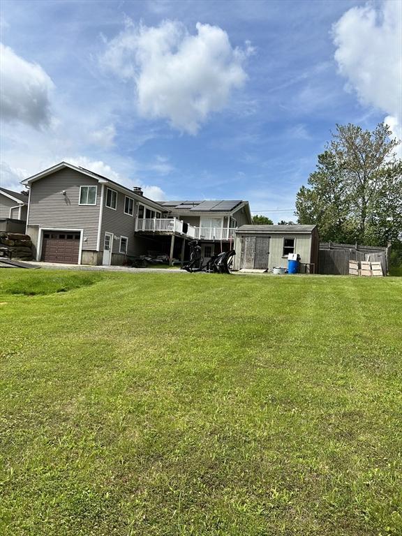 554 Main St, Becket, MA 01223 - back of property with a garage, a shed, a lawn, and a wooden deck