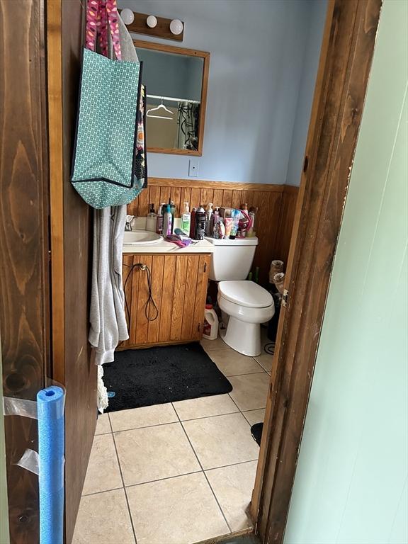 554 Main St, Becket, MA 01223 - full bathroom featuring vanity, a wainscoted wall, tile patterned flooring, toilet, and wood walls