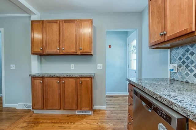 62 Forest St, Middleboro, MA 02346 - kitchen with stainless steel dishwasher, light wood-style flooring, decorative backsplash, and brown cabinetry