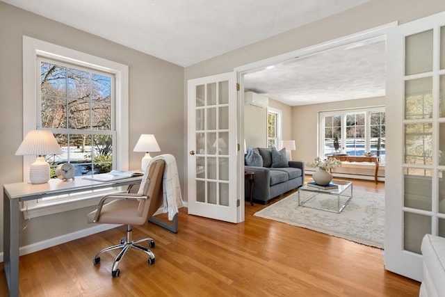 office space featuring a wealth of natural light, wood finished floors, and a wall mounted AC