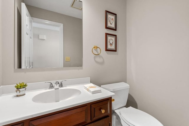 half bath featuring visible vents, vanity, and toilet