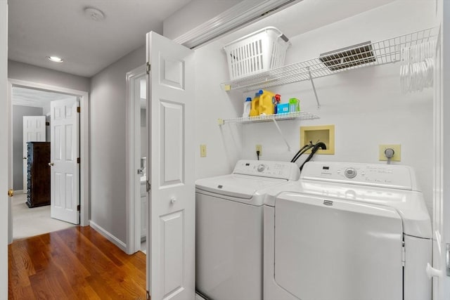 clothes washing area with recessed lighting, wood finished floors, laundry area, independent washer and dryer, and baseboards