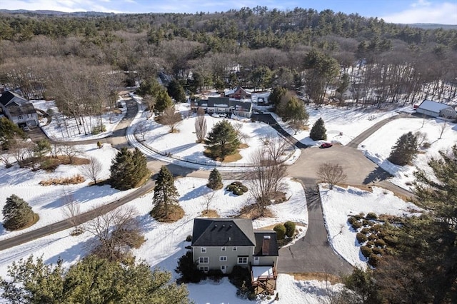 snowy aerial view featuring a forest view