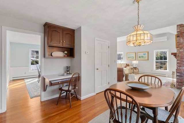 dining space with light wood-type flooring, baseboards, baseboard heating, and a wall mounted AC