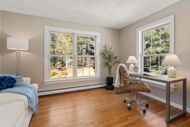 office area with baseboards, baseboard heating, and wood finished floors