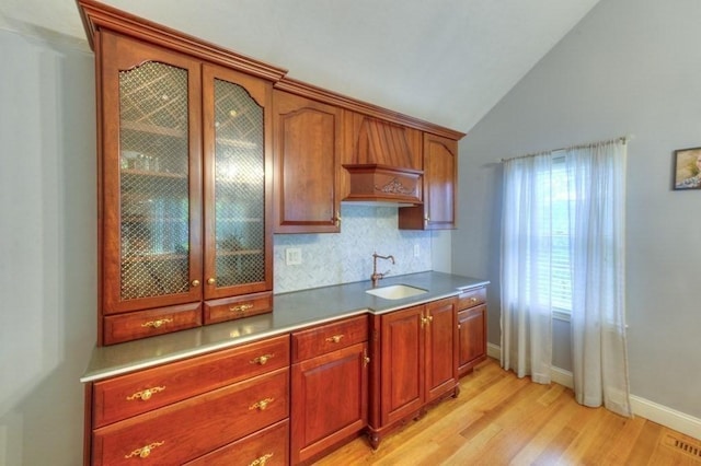 15 Bailin Dr, Worcester, MA 01604 - kitchen with a sink, light wood-style flooring, lofted ceiling, backsplash, and glass insert cabinets