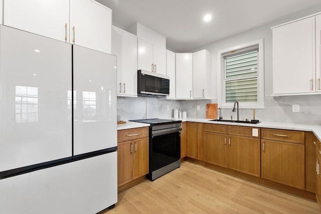 kitchen featuring white cabinetry, sink, electric range, and white fridge