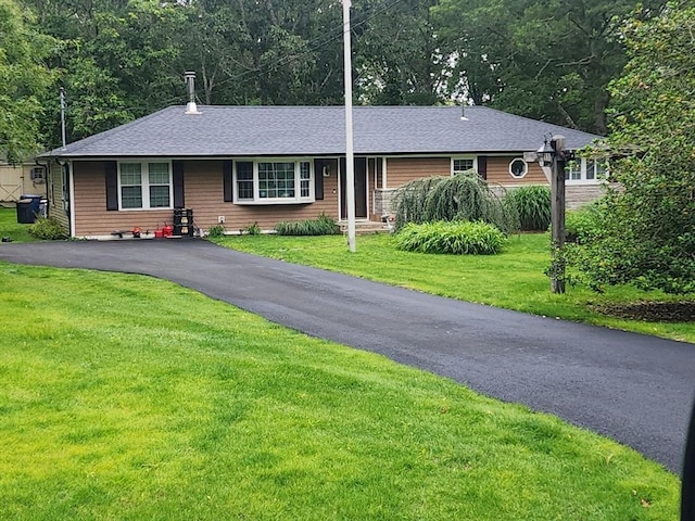 single story home with a front lawn, driveway, and roof with shingles