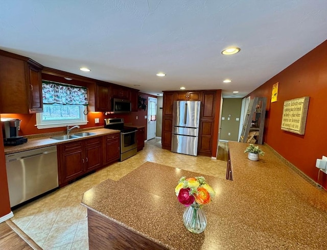 kitchen featuring recessed lighting, a sink, stainless steel appliances, and light countertops