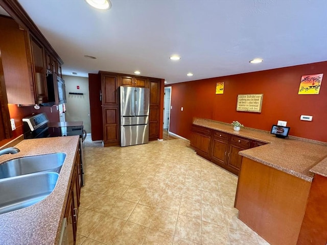 kitchen with recessed lighting, light tile patterned floors, appliances with stainless steel finishes, a sink, and a peninsula