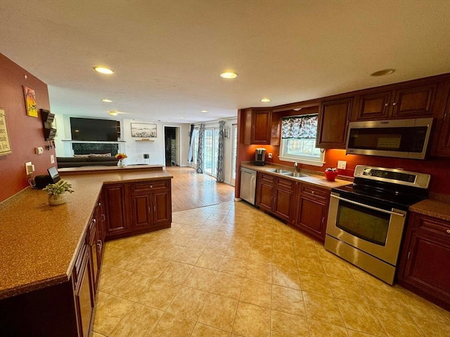 kitchen with recessed lighting, a sink, appliances with stainless steel finishes, and open floor plan