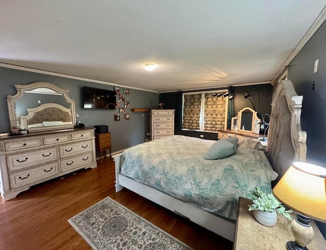 bedroom with wood finished floors and crown molding