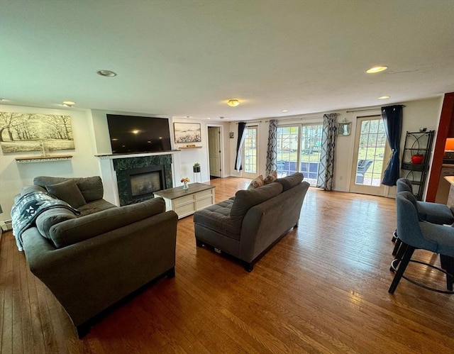 living room with hardwood / wood-style floors, recessed lighting, and a fireplace