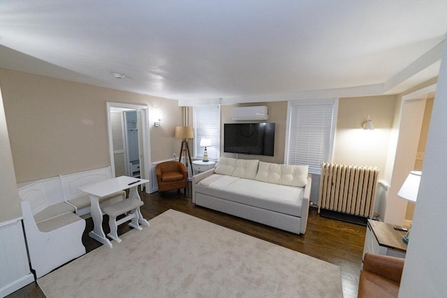 living room featuring radiator, dark hardwood / wood-style flooring, and a wall unit AC