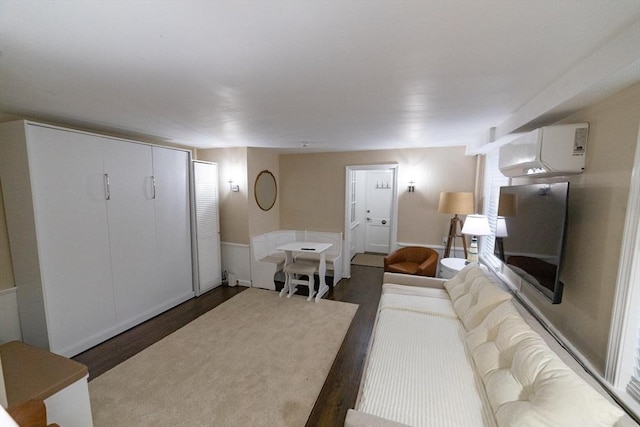 living room with a wall mounted AC and dark hardwood / wood-style floors