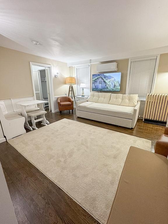 living room featuring hardwood / wood-style flooring and a wall mounted air conditioner