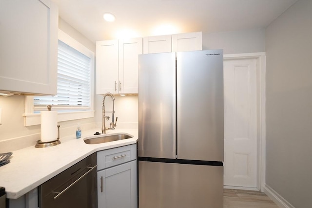 kitchen with sink, white cabinetry, stainless steel fridge, and dishwasher