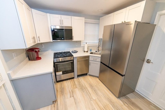 kitchen featuring light hardwood / wood-style floors, white cabinets, and stainless steel appliances