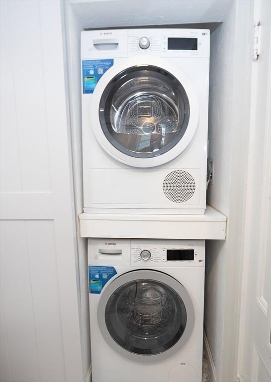 laundry room with stacked washing maching and dryer