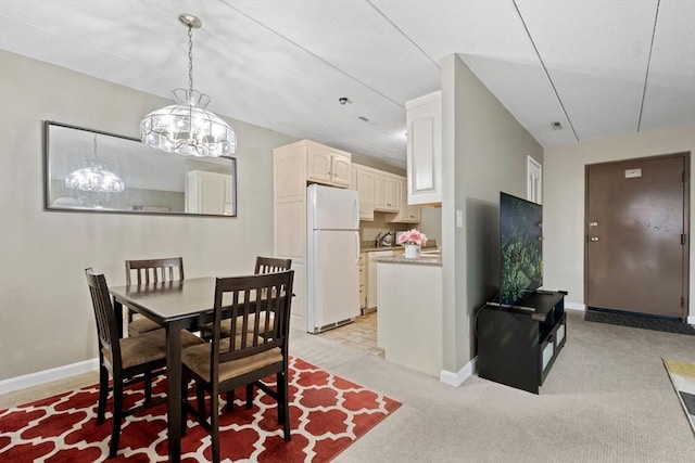 10 Foster St Unit 203, Wakefield, MA 01880 - dining space featuring baseboards, light carpet, and an inviting chandelier