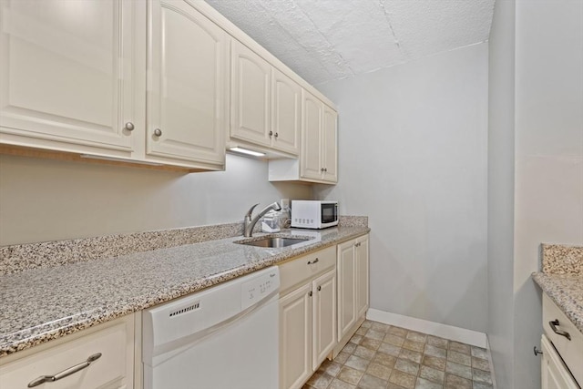 10 Foster St Unit 203, Wakefield, MA 01880 - kitchen with a sink, a textured ceiling, baseboards, light stone countertops, and white appliances