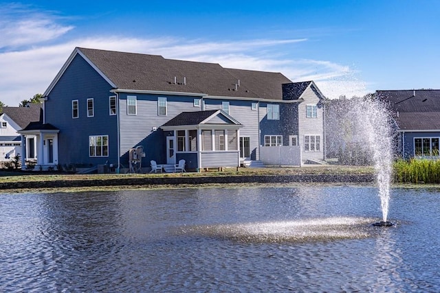 rear view of property featuring a water view and a sunroom