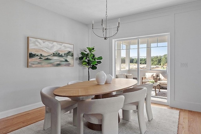 dining space featuring light hardwood / wood-style flooring and a chandelier