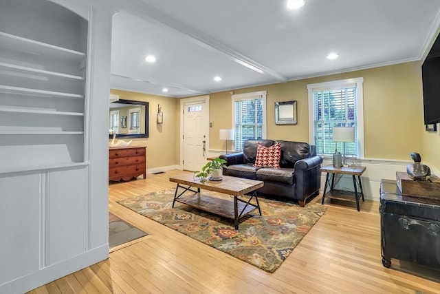 living room featuring ornamental molding, light wood-style flooring, and recessed lighting