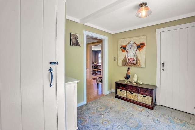 hallway featuring baseboards and beam ceiling