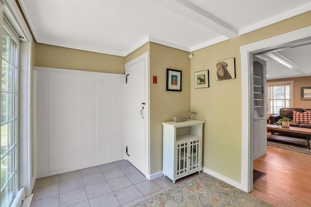 hallway with light tile patterned flooring and beamed ceiling