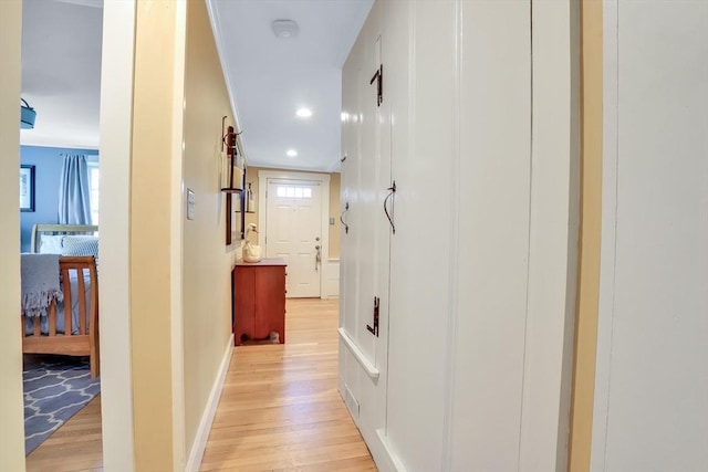 hall featuring light wood-type flooring, recessed lighting, and baseboards
