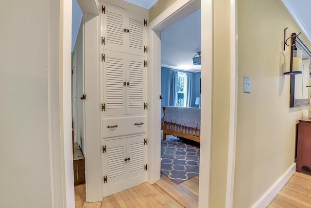 hall with light wood-style floors and baseboards