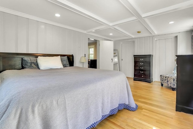 bedroom featuring wood finished floors, coffered ceiling, beamed ceiling, recessed lighting, and a decorative wall