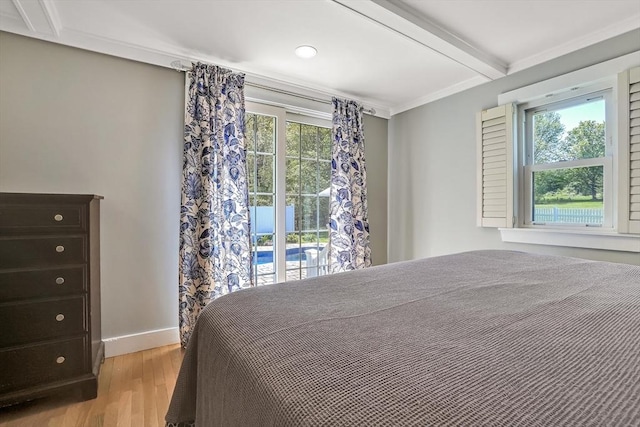 bedroom with light wood-style flooring, beamed ceiling, and baseboards