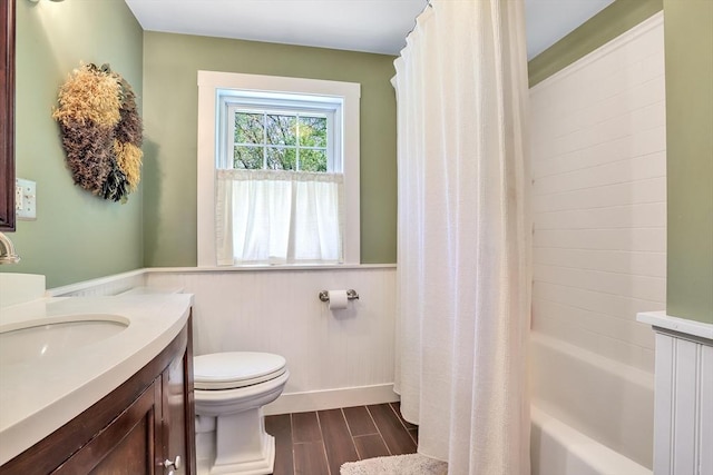 full bathroom featuring toilet, wainscoting, wood finished floors, vanity, and shower / tub combo with curtain