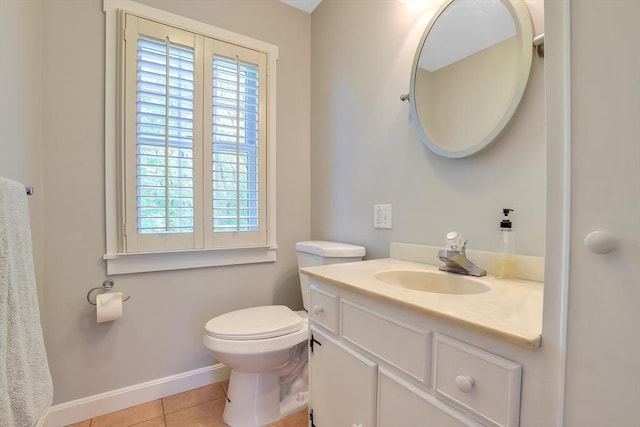 bathroom with tile patterned flooring, toilet, vanity, and baseboards